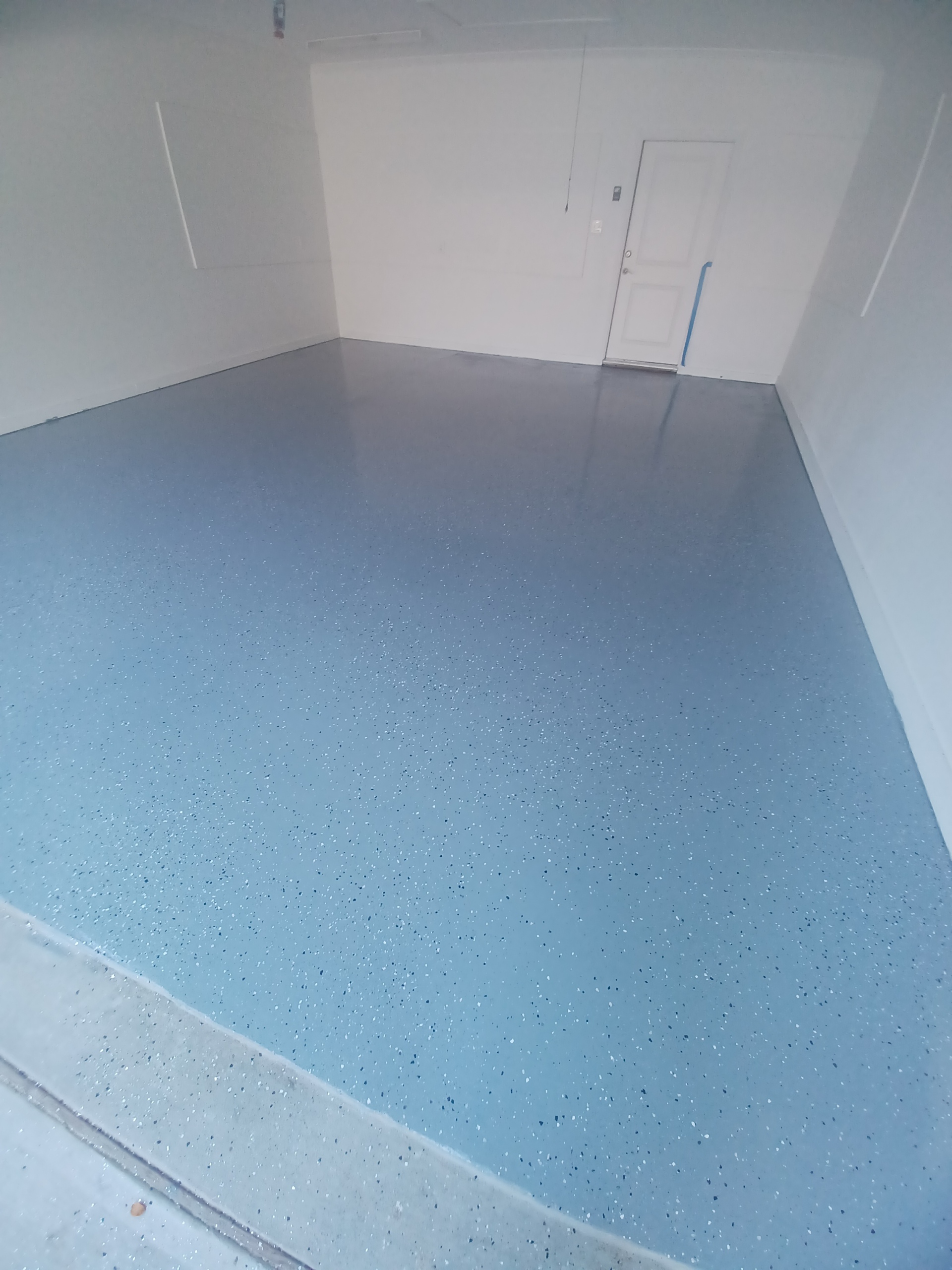 Garage with high-end epoxy floor coating installed by Concord Roofing & Construction